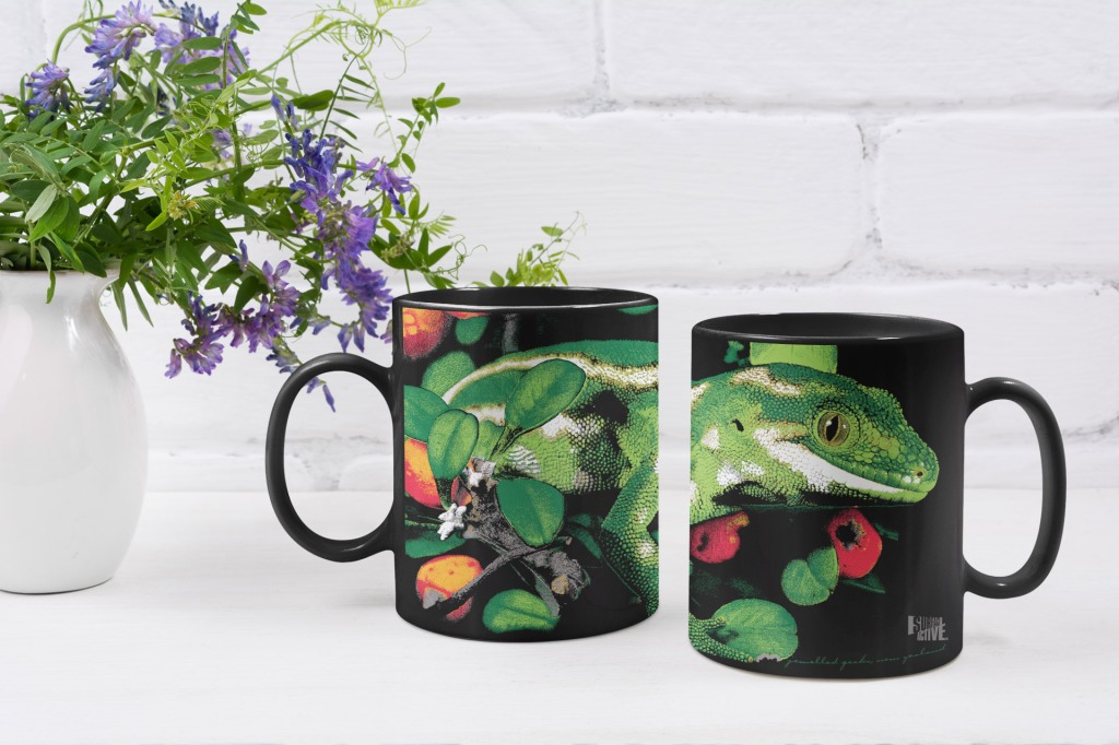 Two black jewelled gecko coffee mugs with a floral centrepiece.
